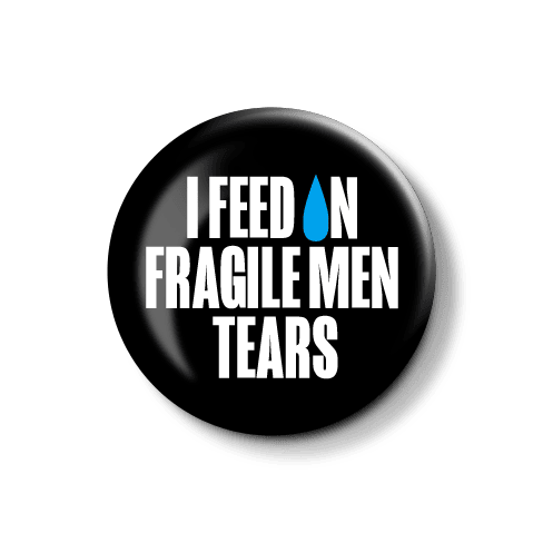 Stilvoller Button mit provokantem Spruch über die Empfindsamkeit von Männern. Button mit der Aufschrift "I FEED ON FRAGILE MEN TEARS", design in Schwarz und Blau.