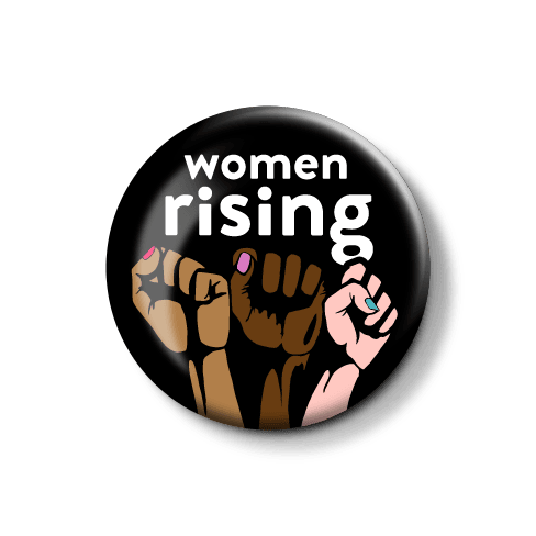 "Frauen stehen auf – solidarischer Button für Gleichberechtigung." Button mit der Aufschrift "women rising" und symbolischen erhobenen Fäusten in verschiedenen Hauttönen.