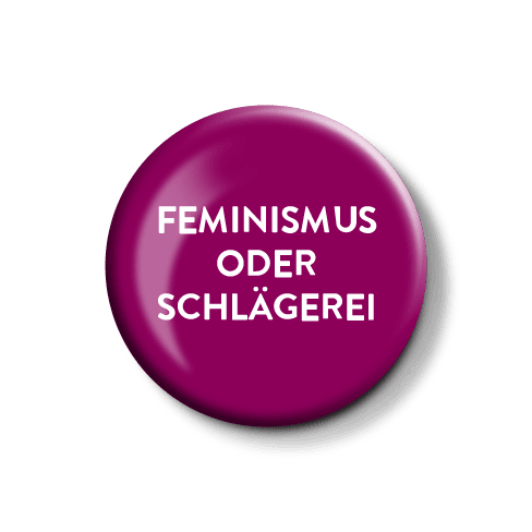 Anstecknadel mit feministischer Botschaft. Lila Anstecknadel mit dem Aufdruck „FEMINISMUS ODER SCHLÄGEREI“.