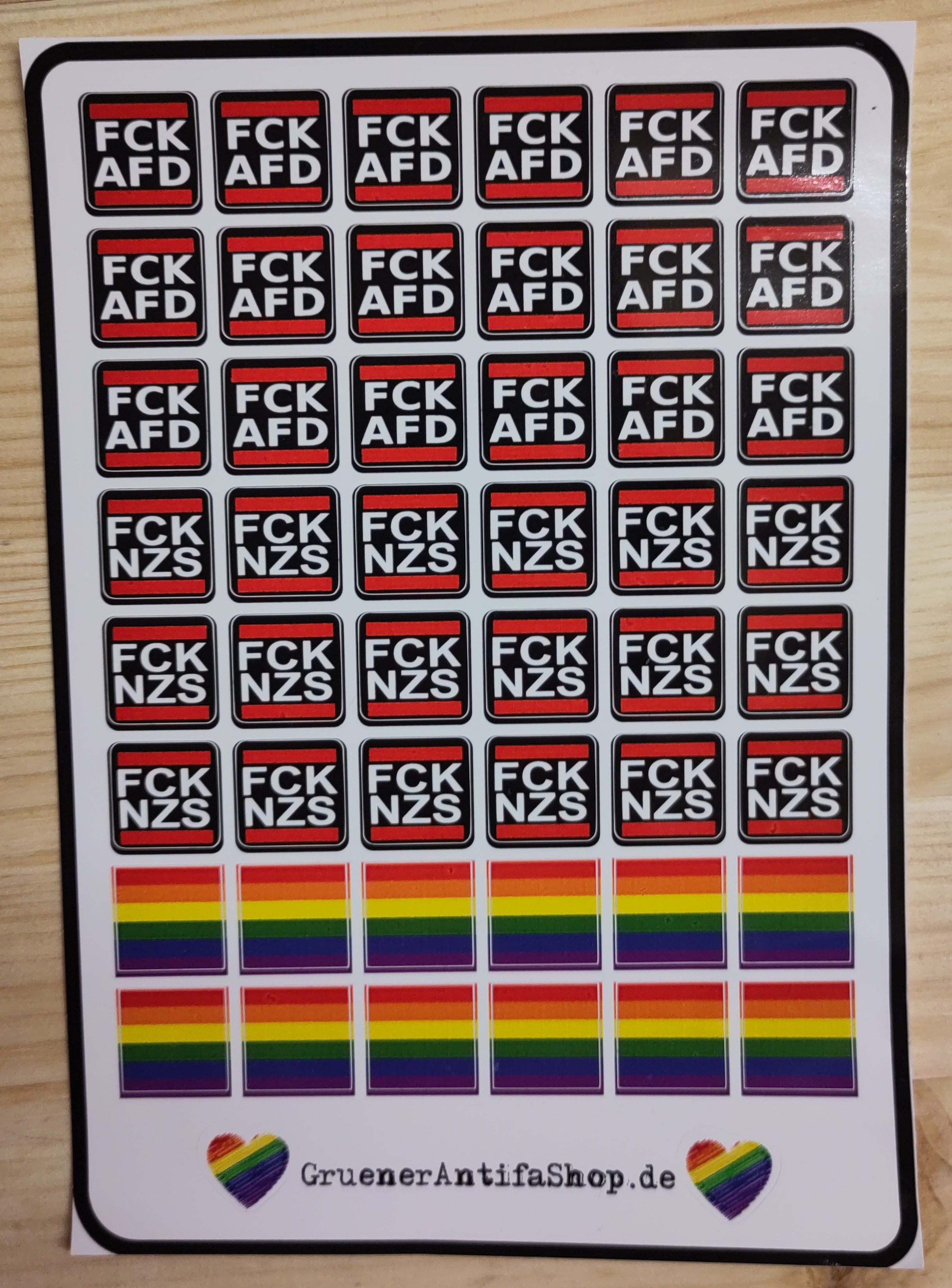 Aufkleberbogen mit politischen Botschaften und Regenbogenflaggen. Ein Aufkleberbogen mit verschiedenen Aufklebern, die politische Botschaften und Regenbogenflaggen zeigen.