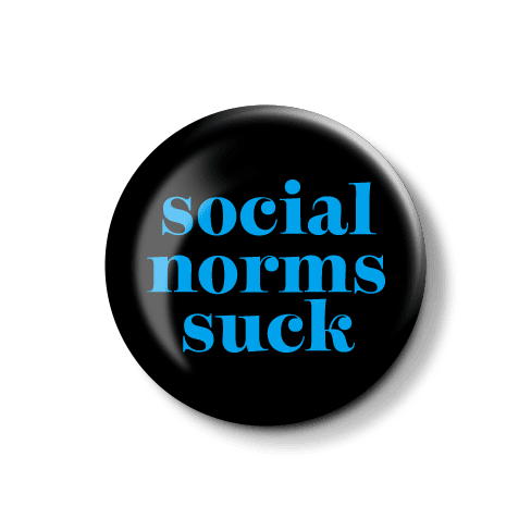 Anstecker mit provokantem Spruch über soziale Normen. Runder Anstecker mit der Aufschrift "social norms suck" in blauer Schrift auf schwarzem Hintergrund.